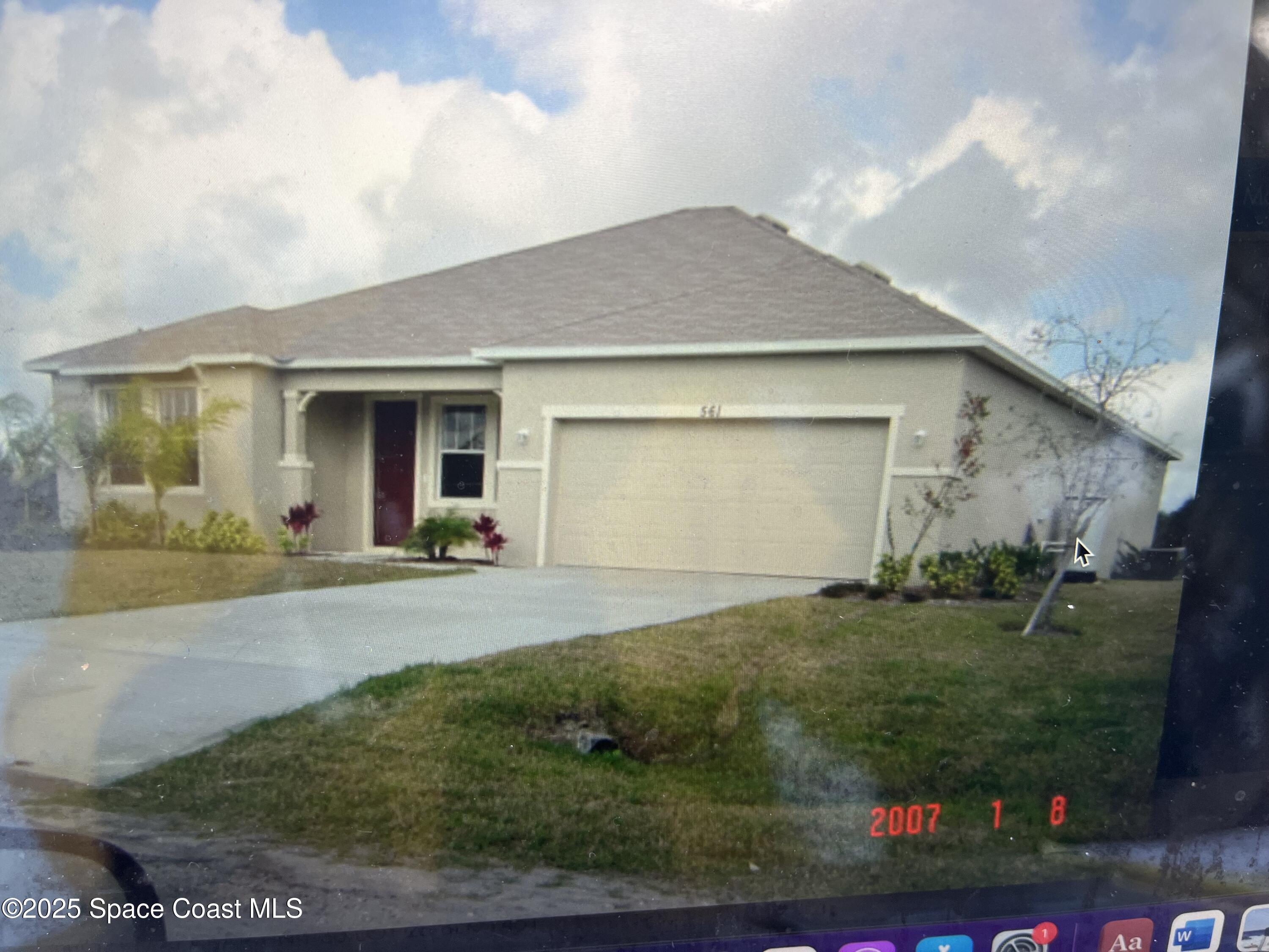 561 Lambert Street Southwest Palm Bay, FL 32908 - Photo 1 of 10 a front view of a house with a yard and garage