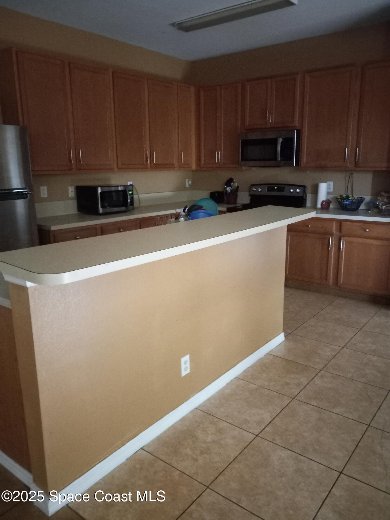 561 Lambert Street Southwest Palm Bay, FL 32908 - Photo 2 of 10 a kitchen with a sink a stove top oven and cabinets