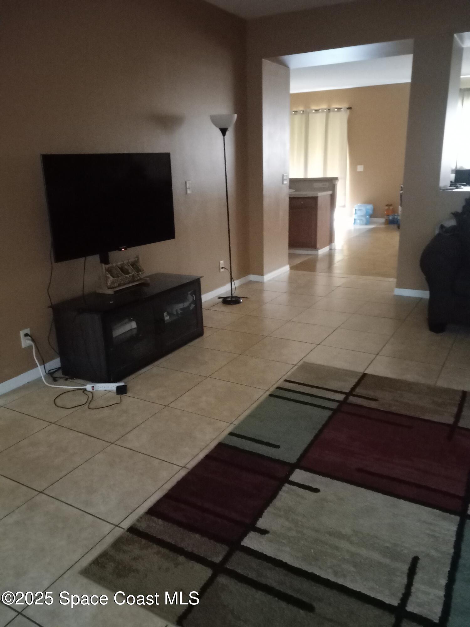 561 Lambert Street Southwest Palm Bay, FL 32908 - Photo 4 of 10 a living room with furniture and a flat screen tv