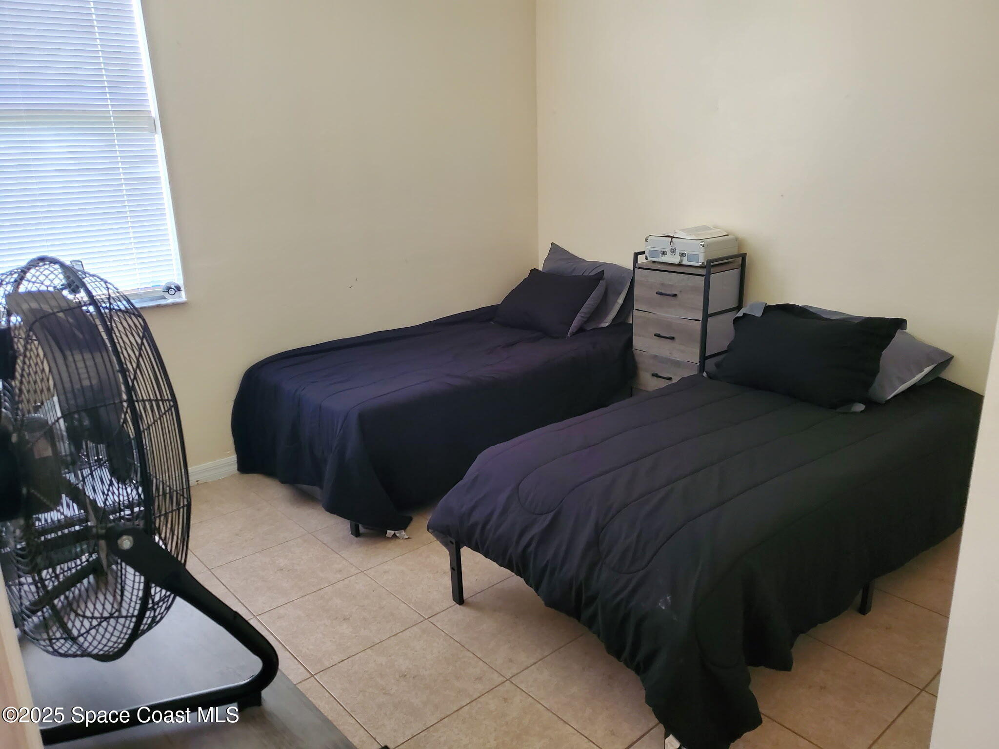 561 Lambert Street Southwest Palm Bay, FL 32908 - Photo 5 of 10 a bedroom with two beds and a couch