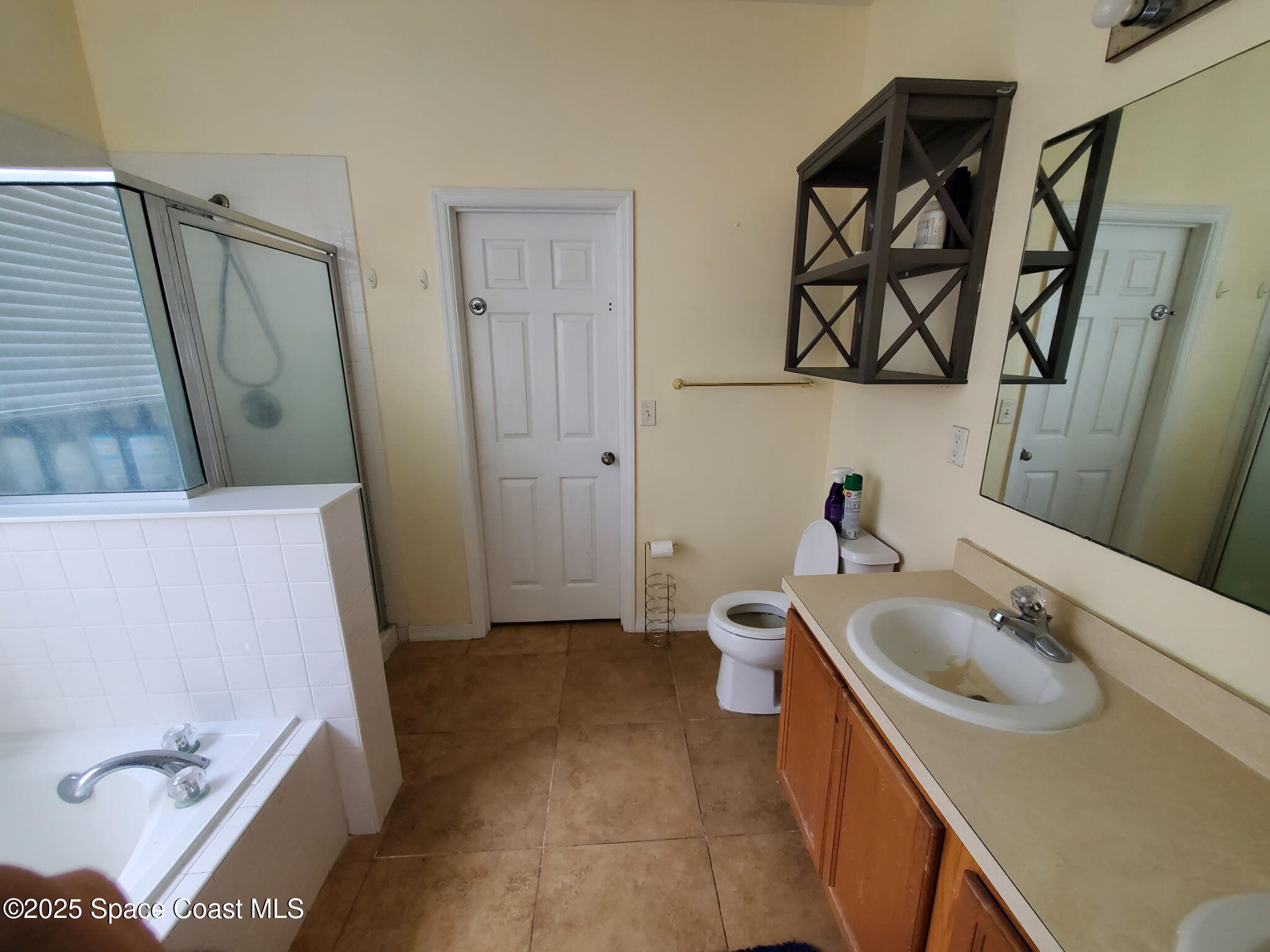 561 Lambert Street Southwest Palm Bay, FL 32908 - Photo 7 of 10 a bathroom with a tub sink and mirror
