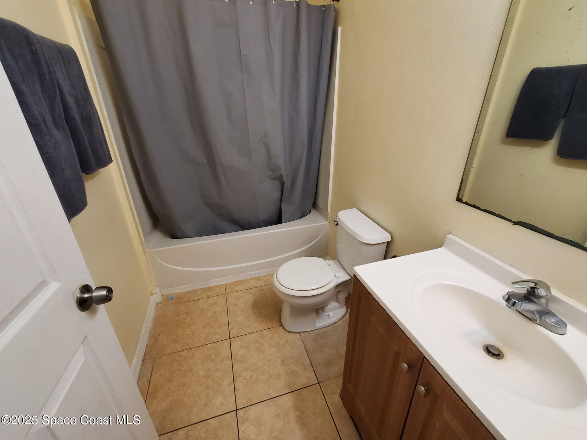 561 Lambert Street Southwest Palm Bay, FL 32908 - Photo 8 of 10 a bathroom with a sink a toilet and shower curtain