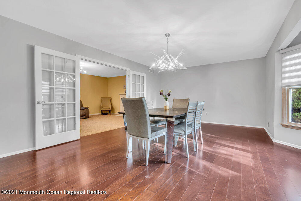 67 Chelsea Road Jackson, NJ 08527 - Photo 14 of 53 a dining room with wooden floor a chandelier a glass table and chairs