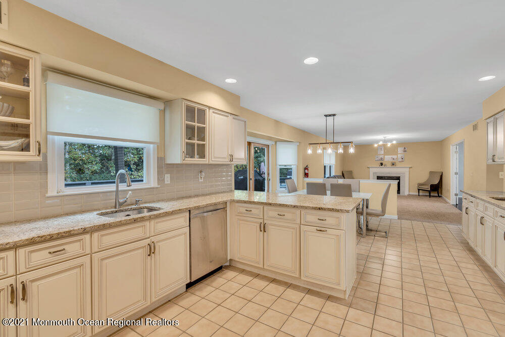 67 Chelsea Road Jackson, NJ 08527 - Photo 27 of 53 a kitchen with a sink white cabinets and glass table chairs