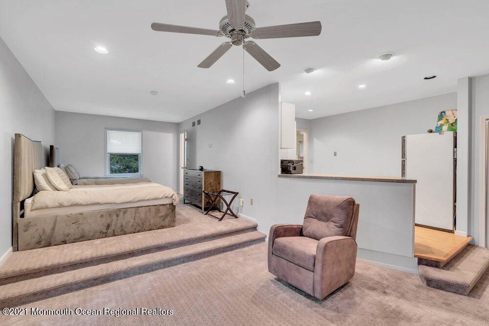 67 Chelsea Road Jackson, NJ 08527 - Photo 32 of 53 a spacious bedroom with a bed a couch and a chandelier