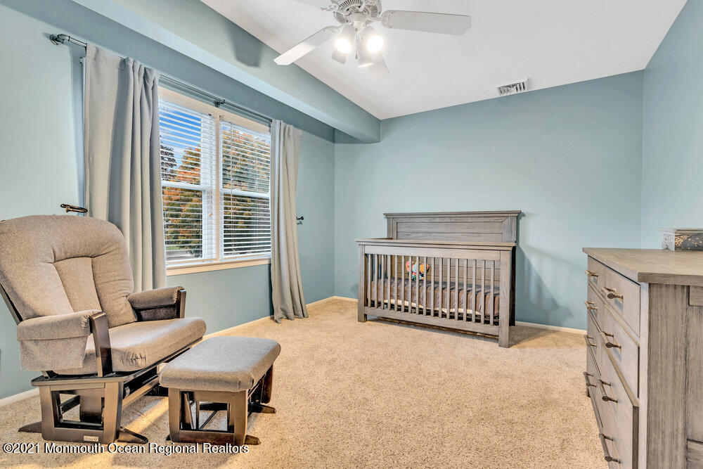 67 Chelsea Road Jackson, NJ 08527 - Photo 35 of 53 a bedroom with a bed and a chandelier