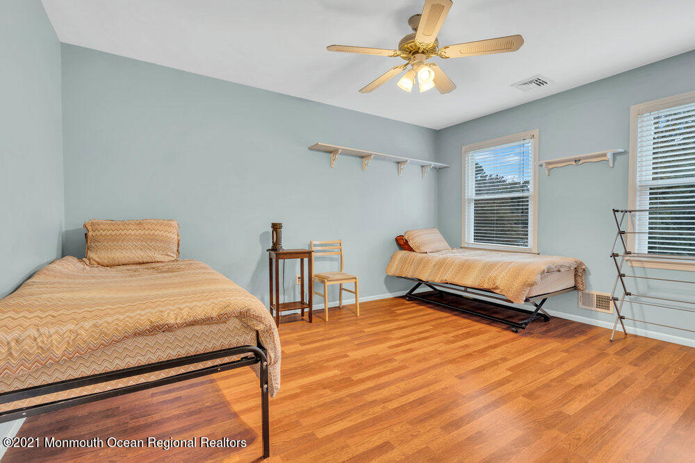 67 Chelsea Road Jackson, NJ 08527 - Photo 36 of 53 a bedroom with a bed and a chandelier