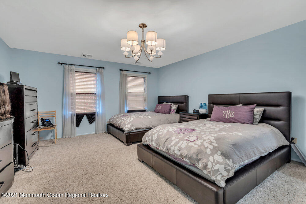67 Chelsea Road Jackson, NJ 08527 - Photo 39 of 53 a spacious bedroom with two beds and a chandelier