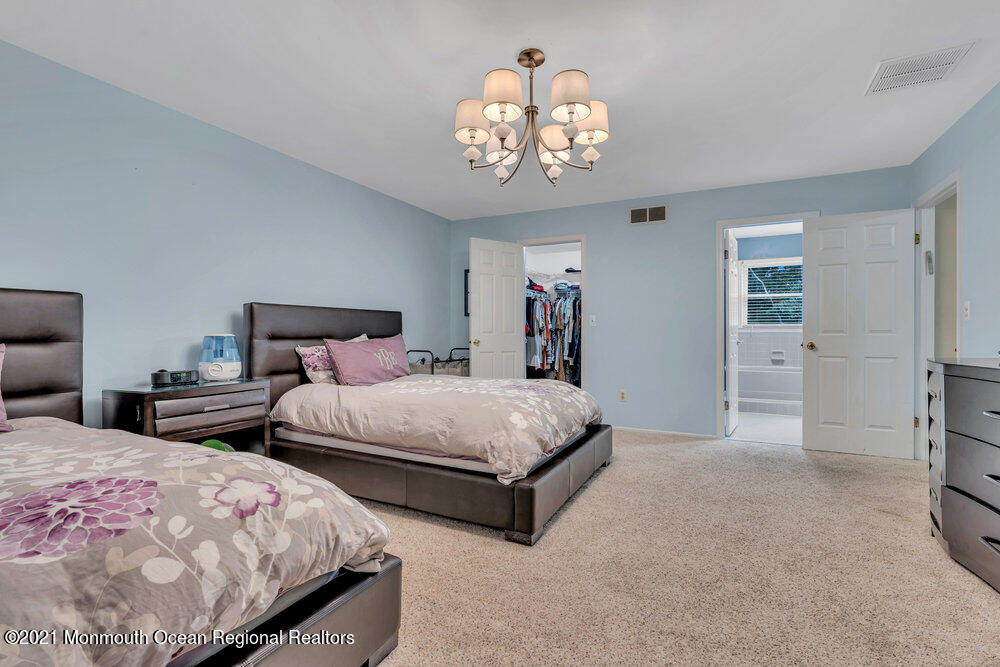 67 Chelsea Road Jackson, NJ 08527 - Photo 40 of 53 a bedroom with bed and a chandelier
