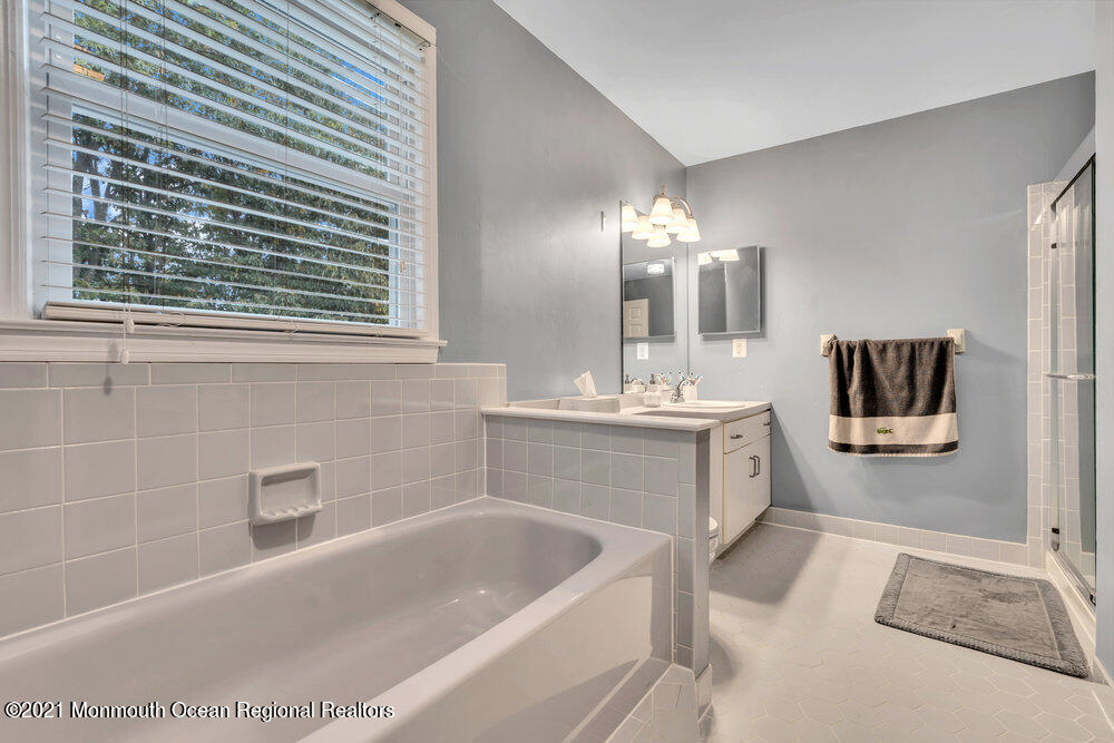 67 Chelsea Road Jackson, NJ 08527 - Photo 42 of 53 a bathroom with a tub a sink and a mirror