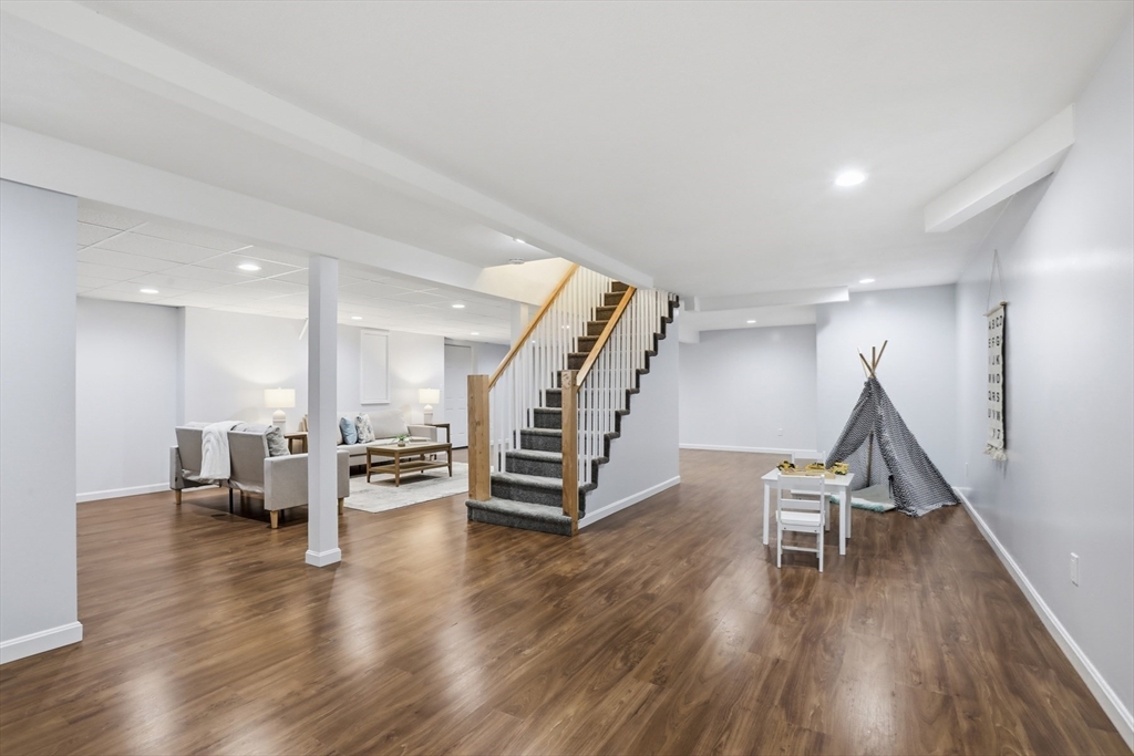 94 Johnson Road Winchester, MA 01890 - Photo 29 of 40 a room with wooden floors stairs and white walls