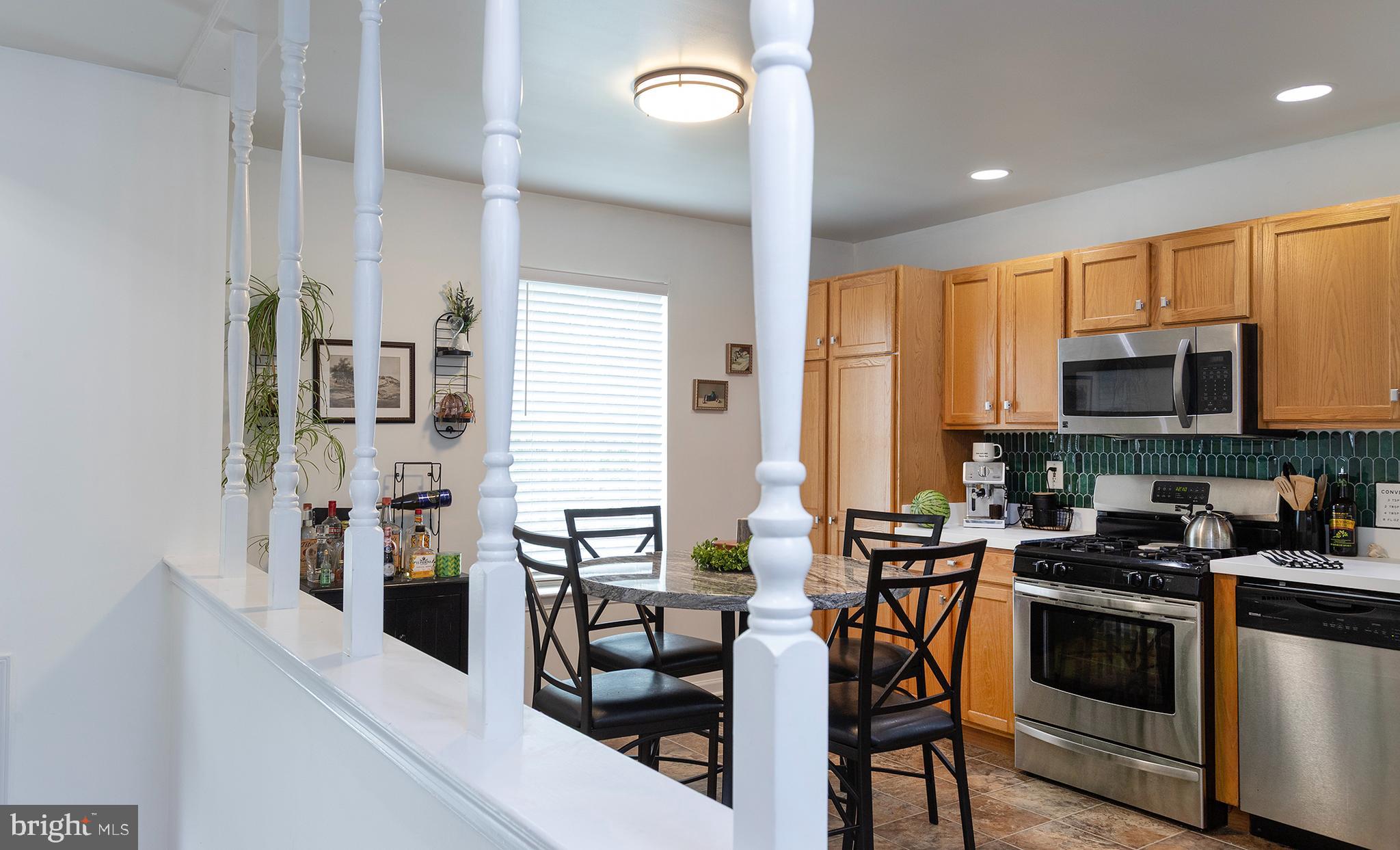 606 Butterfly Circle Dallastown, PA 17313 - Photo 6 of 40 a kitchen with stainless steel appliances a table chairs and a refrigerator