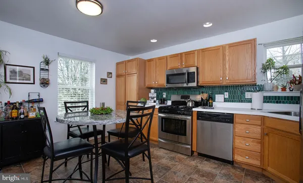 a kitchen with a table chairs microwave and cabinets