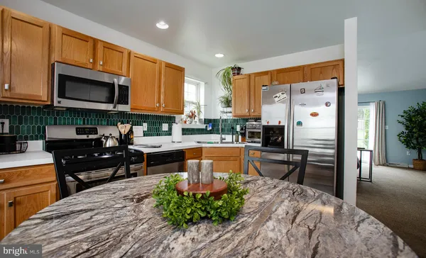 a kitchen with stainless steel appliances granite countertop a refrigerator stove microwave and sink