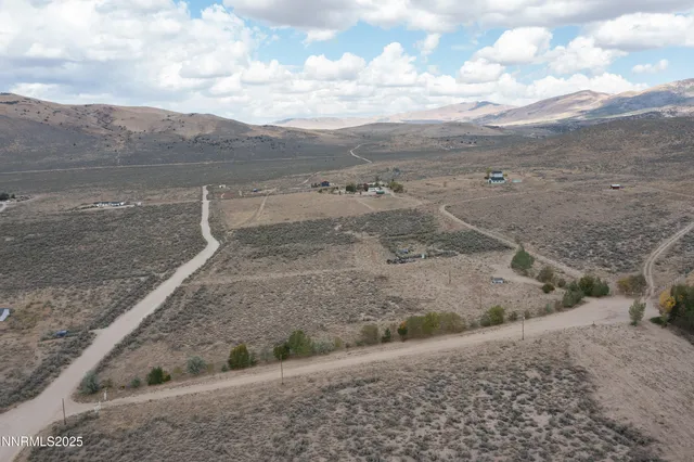 a view of a dry yard with wooden fence