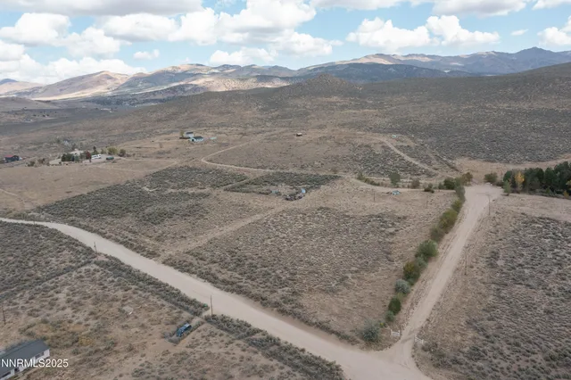 a view of a dry yard with mountains in the background