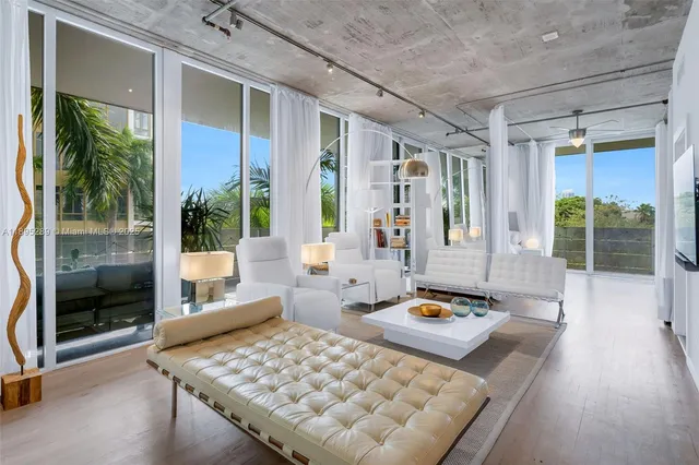 a living room with furniture lamp and large window