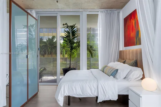 a bedroom with a bed and a potted plant