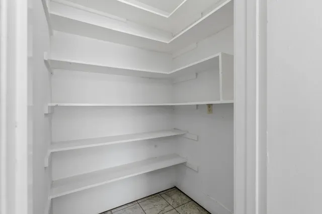 a view of walk in closet with empty racks