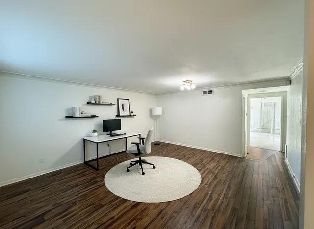 a view of a workspace with wooden floor