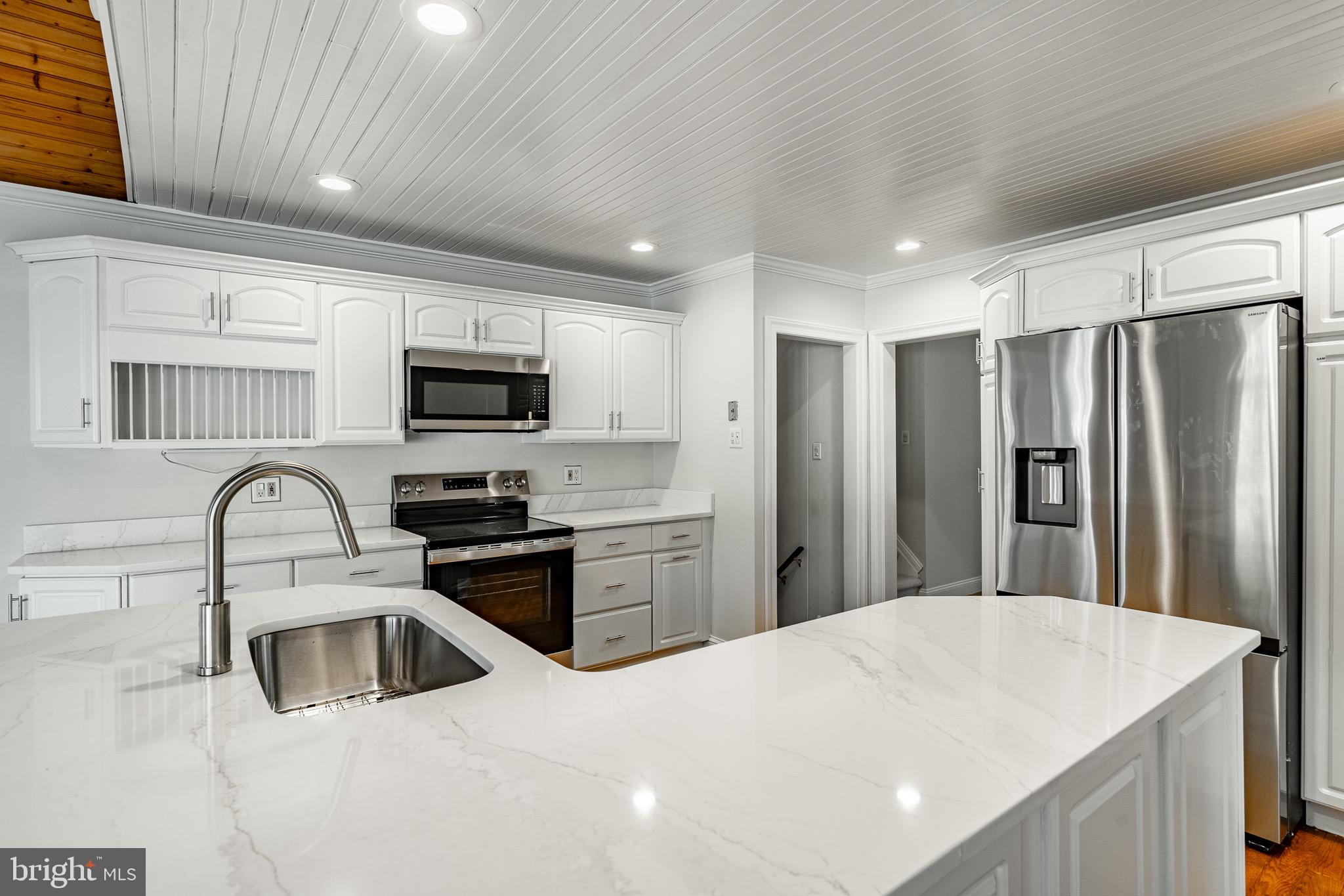 657 Walker Road Wayne, PA 19087 - Photo 29 of 66 a kitchen with granite countertop a refrigerator stove top oven and sink