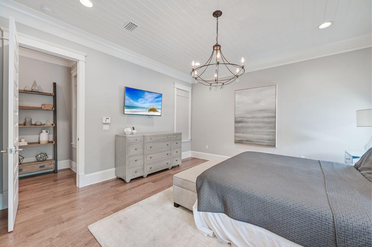 89 Clipper Street Inlet Beach, FL 32461 - Photo 18 of 49 a bedroom with a bed and a chandelier