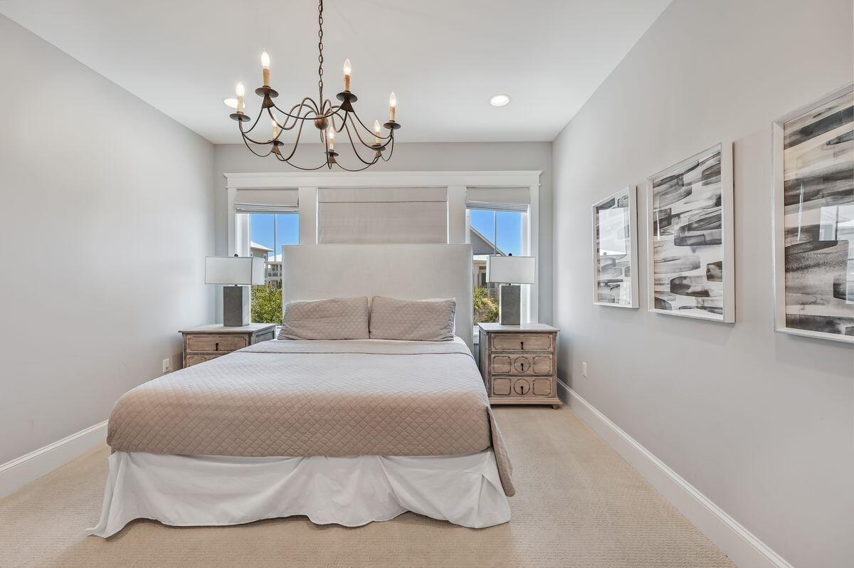 89 Clipper Street Inlet Beach, FL 32461 - Photo 22 of 49 a bedroom with a large bed and a chandelier