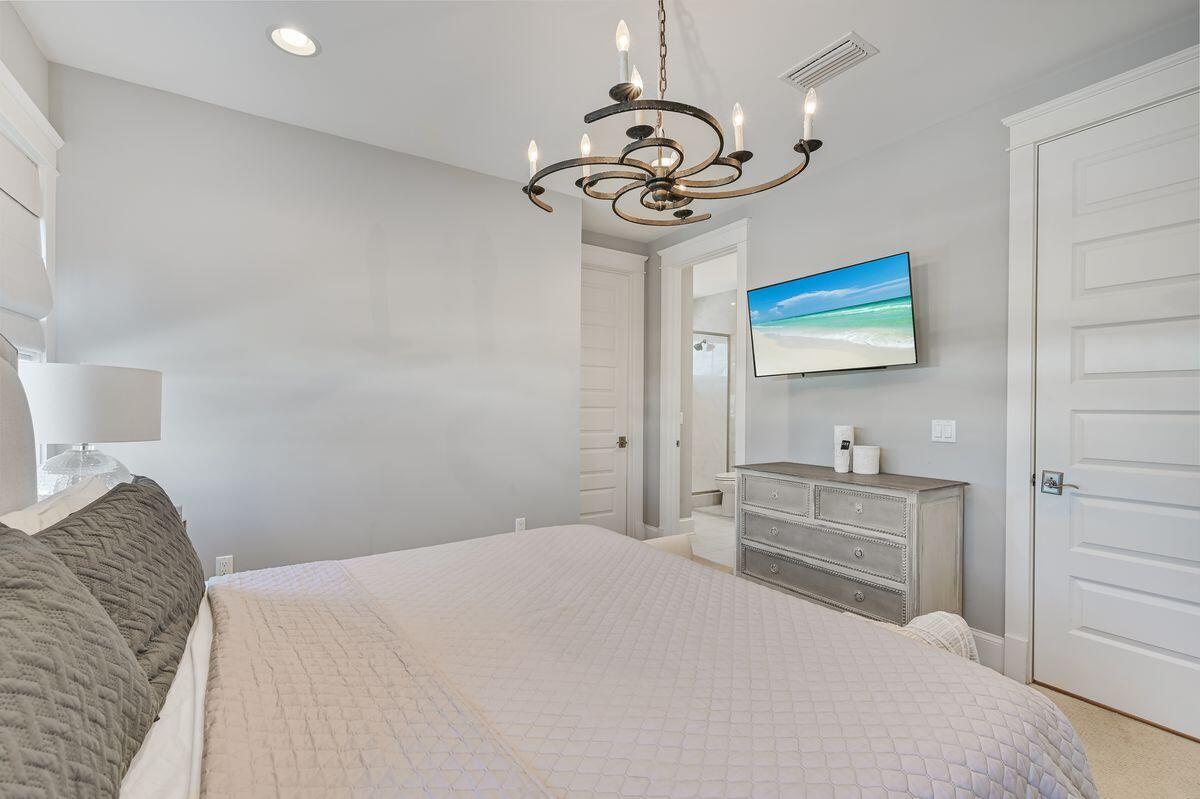 89 Clipper Street Inlet Beach, FL 32461 - Photo 28 of 49 a bedroom with a bed and a chandelier