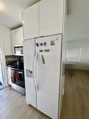 a white refrigerator freezer and a stove sitting inside of a kitchen