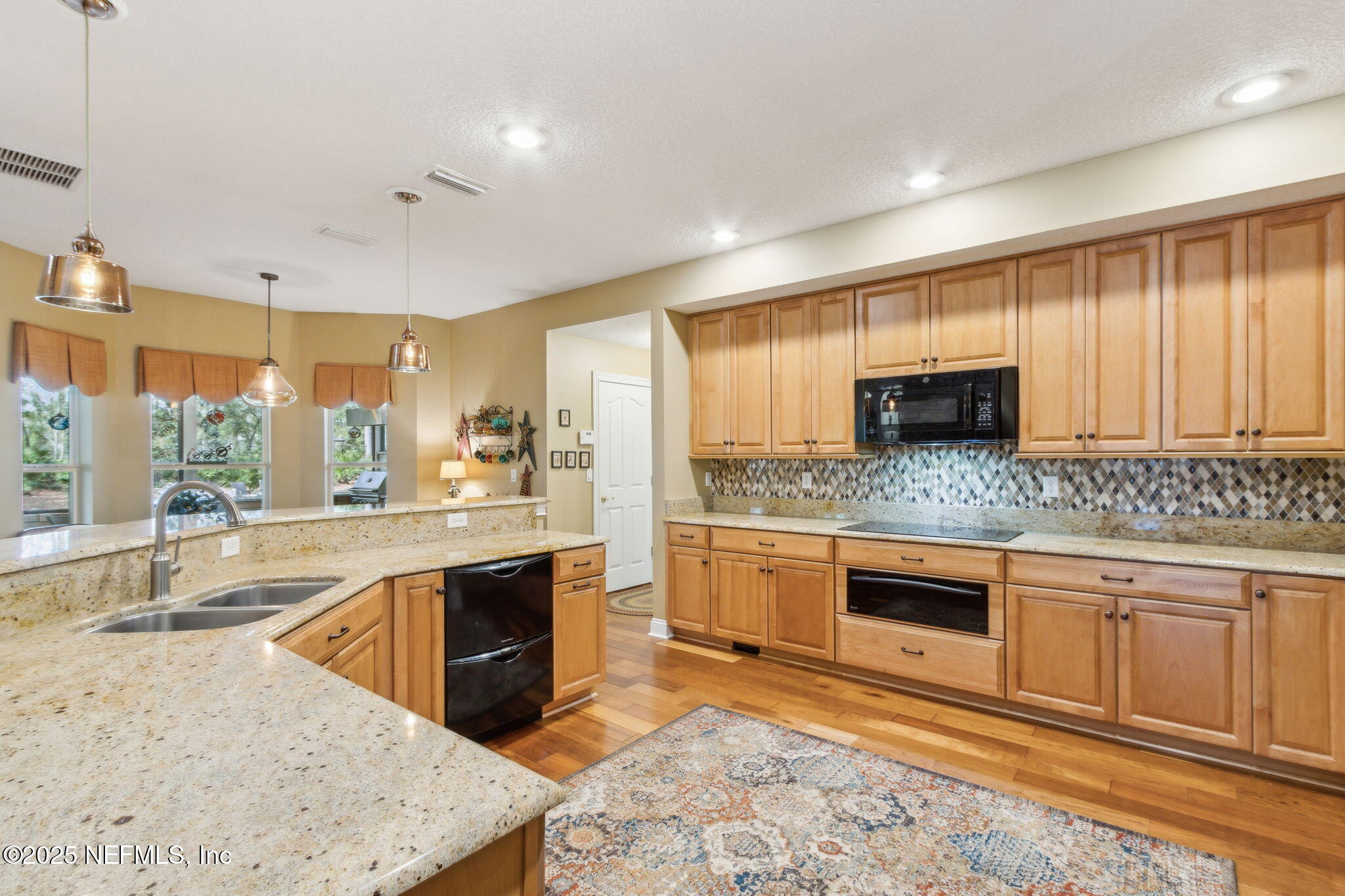96197 Brady Point Road Fernandina Beach, FL 32034 - Photo 11 of 40 a large kitchen with stainless steel appliances granite countertop a stove a sink and a microwave
