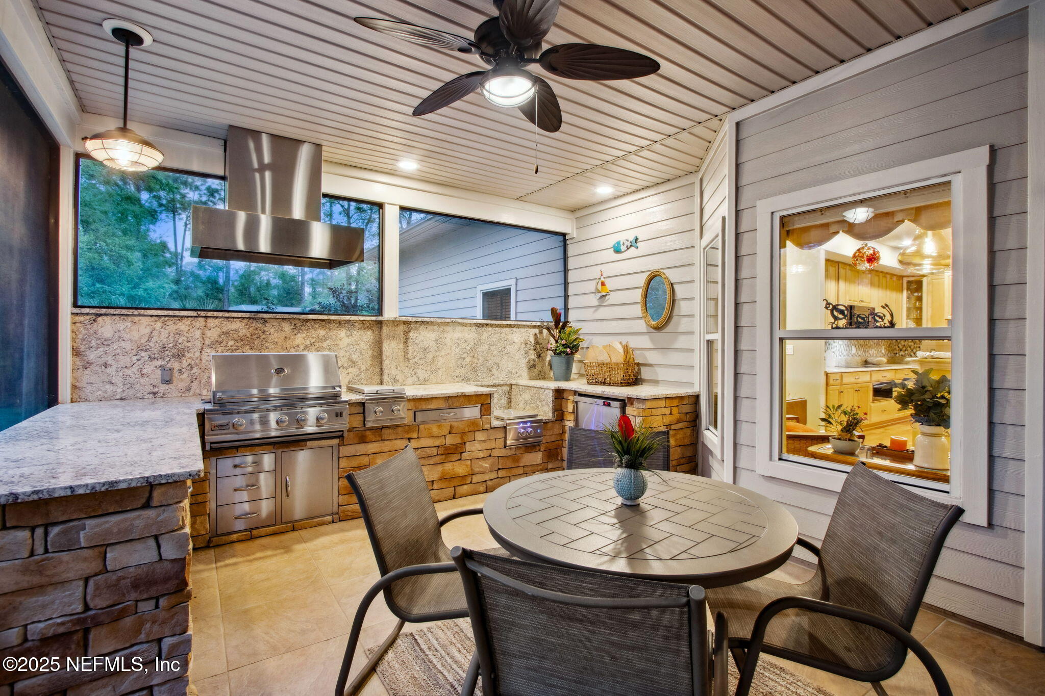 96197 Brady Point Road Fernandina Beach, FL 32034 - Photo 30 of 40 a dining room with furniture a floor to ceiling window and kitchen view