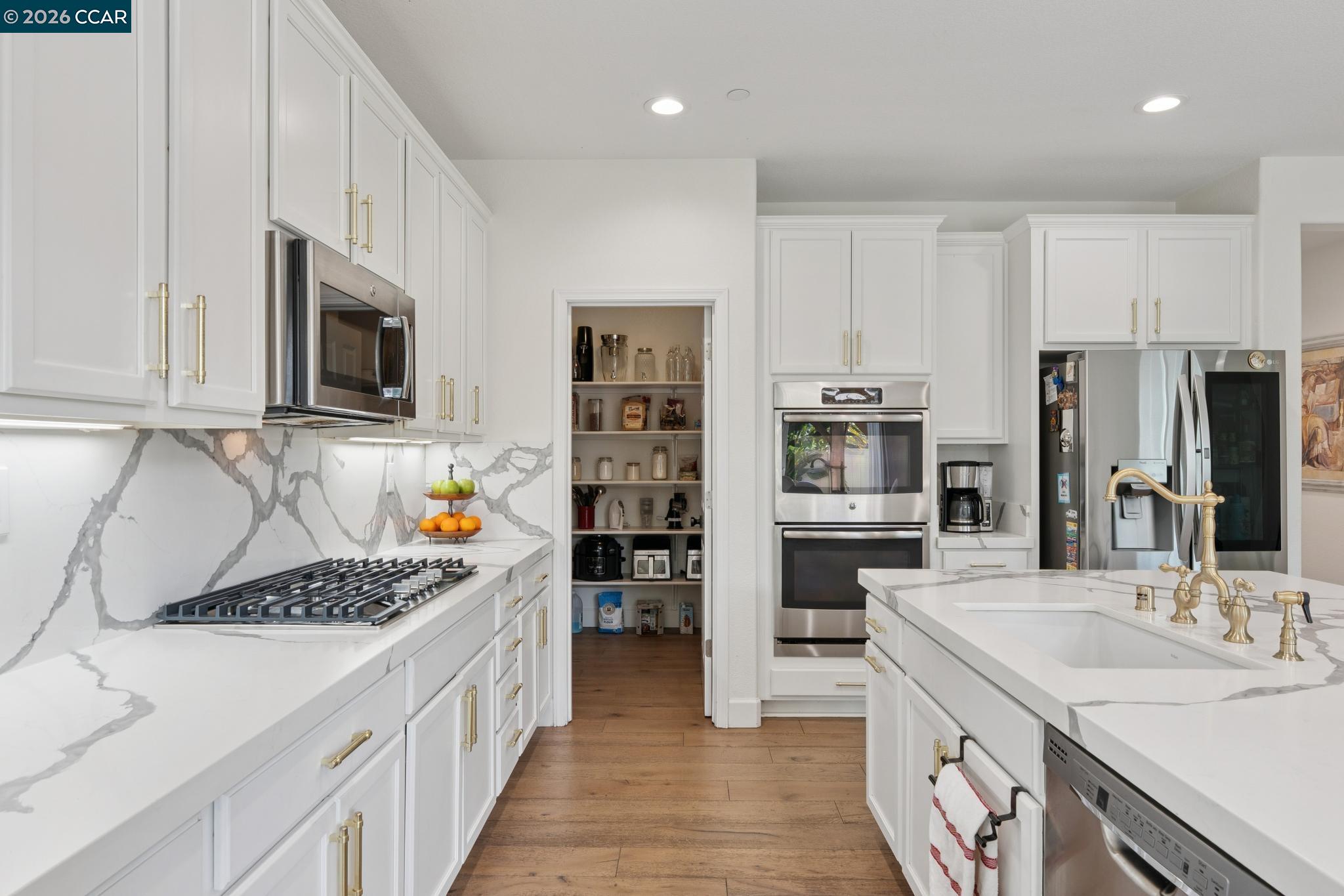 1226 Sierra Trail Road Oakley, CA 94561 - Photo 12 of 60 a kitchen with stainless steel appliances a stove sink microwave and cabinets