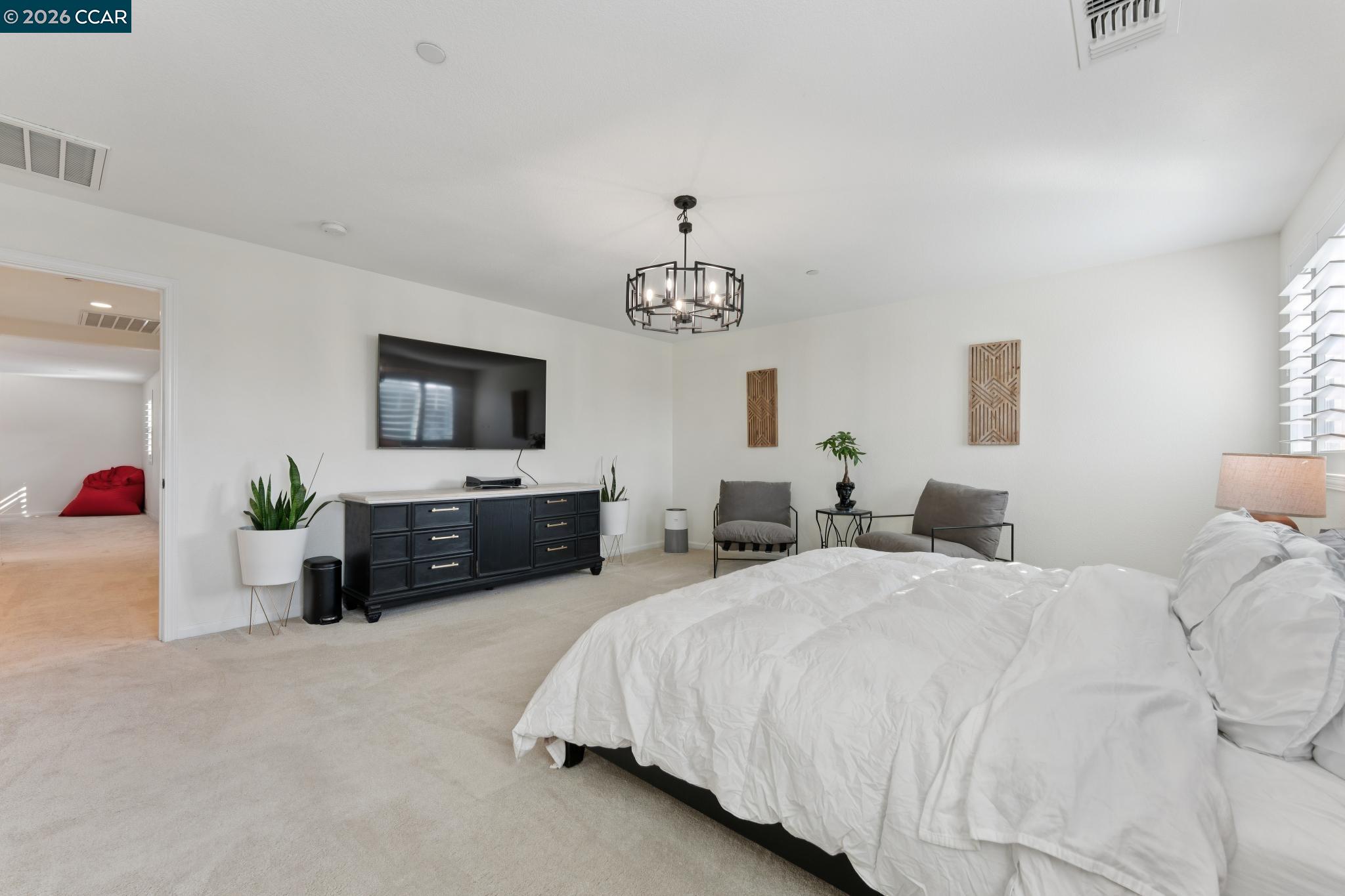 1226 Sierra Trail Road Oakley, CA 94561 - Photo 28 of 60 a spacious bedroom with two beds and a chandelier
