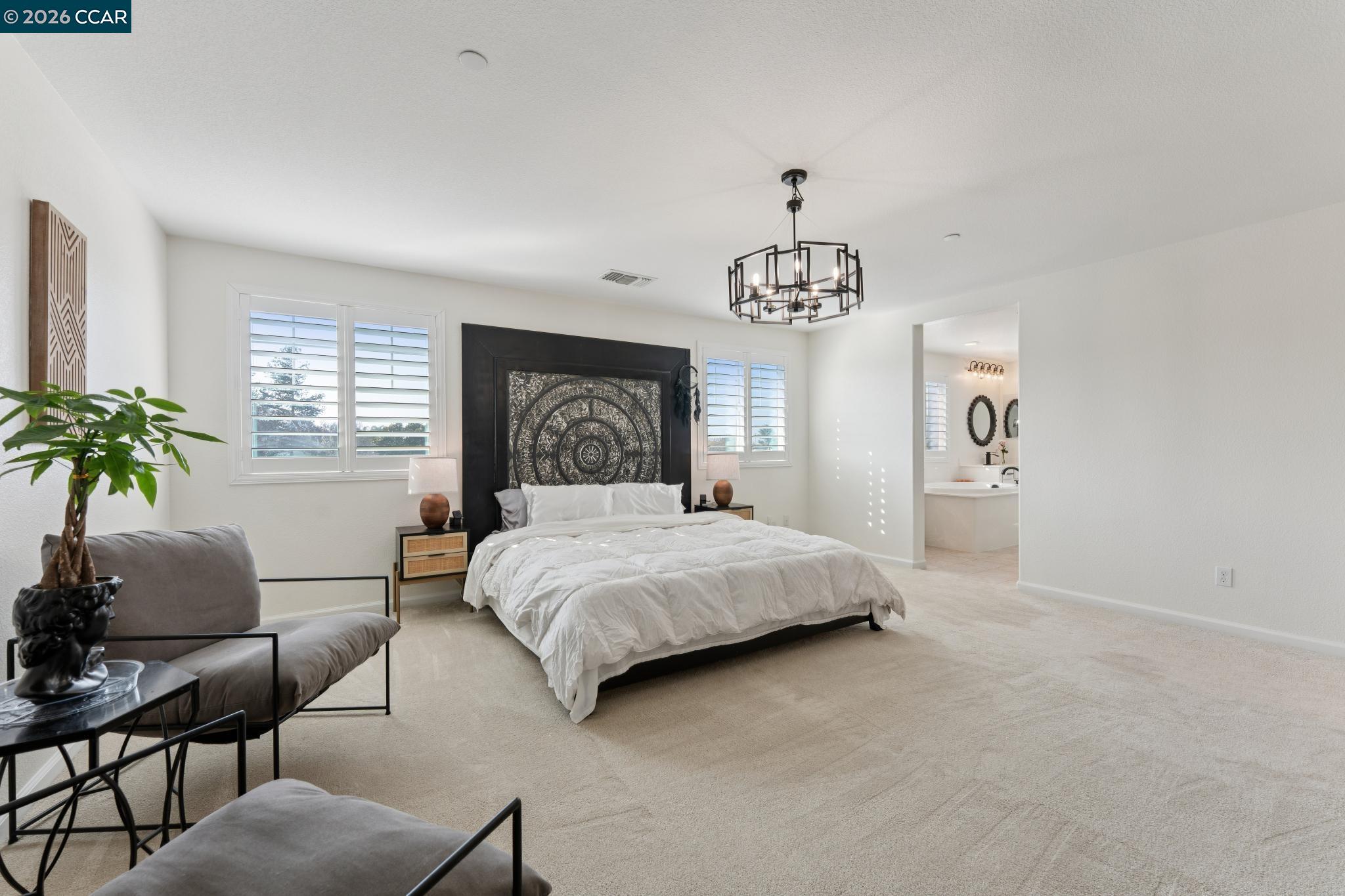 1226 Sierra Trail Road Oakley, CA 94561 - Photo 29 of 60 a bedroom with a large bed and a chandelier