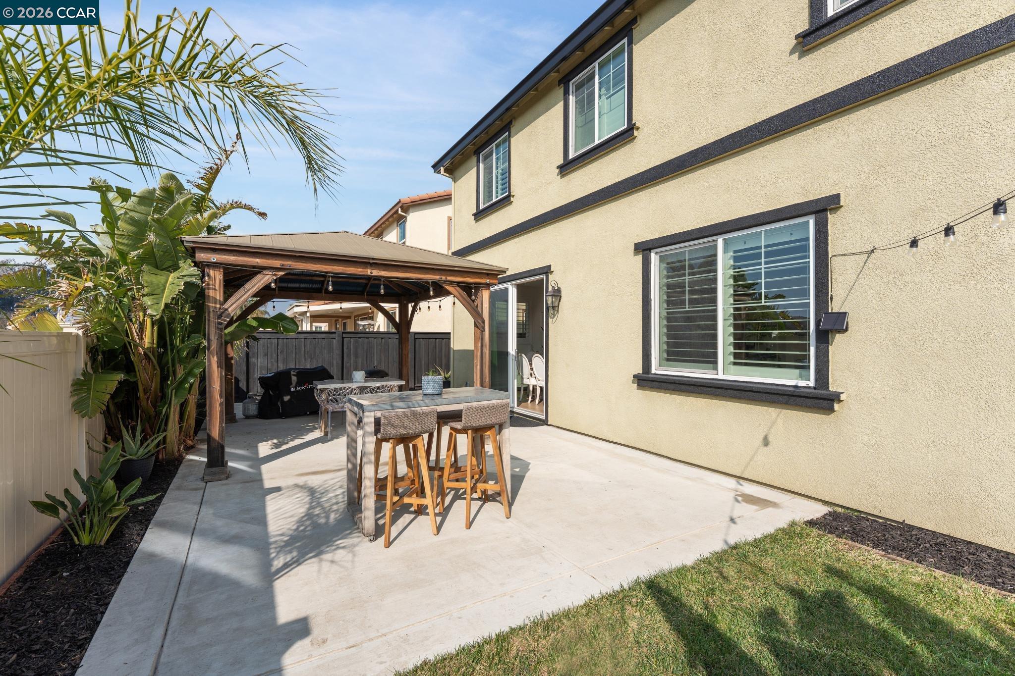 1226 Sierra Trail Road Oakley, CA 94561 - Photo 60 of 60 a view of a patio with table and chairs potted plants and floor to ceiling window