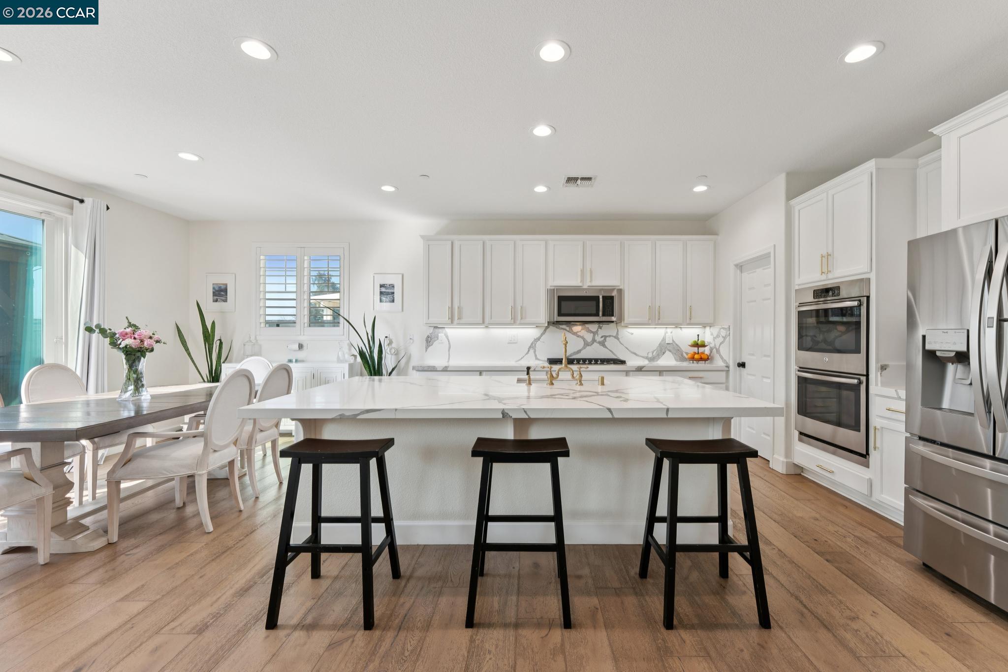 1226 Sierra Trail Road Oakley, CA 94561 - Photo 9 of 60 a kitchen with stainless steel appliances kitchen island granite countertop a table chairs stove and refrigerator