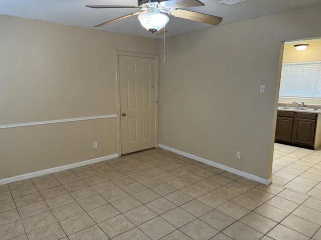 an empty room with kitchen view