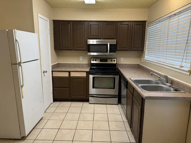 a kitchen with a stove a refrigerator and a sink