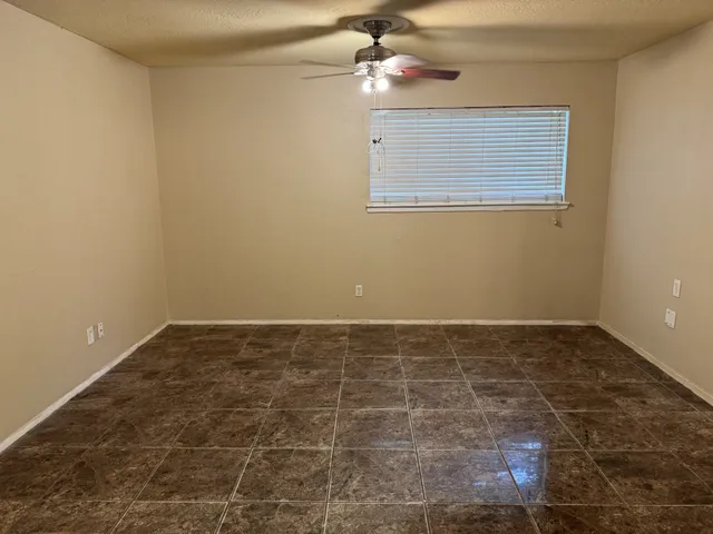 a view of an empty room with a chandelier fan