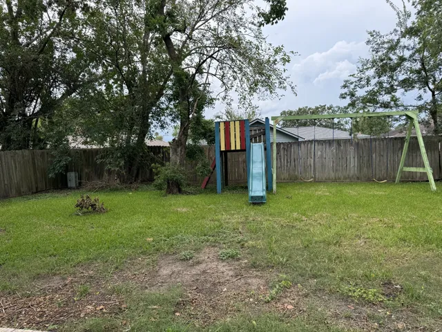 a backyard of a house with lots of plants and tree