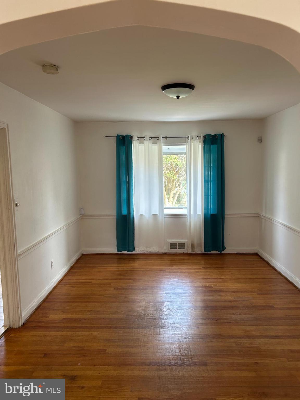 1804 Winford Road Baltimore, MD 21239 - Photo 4 of 18 an empty room with wooden floor and windows