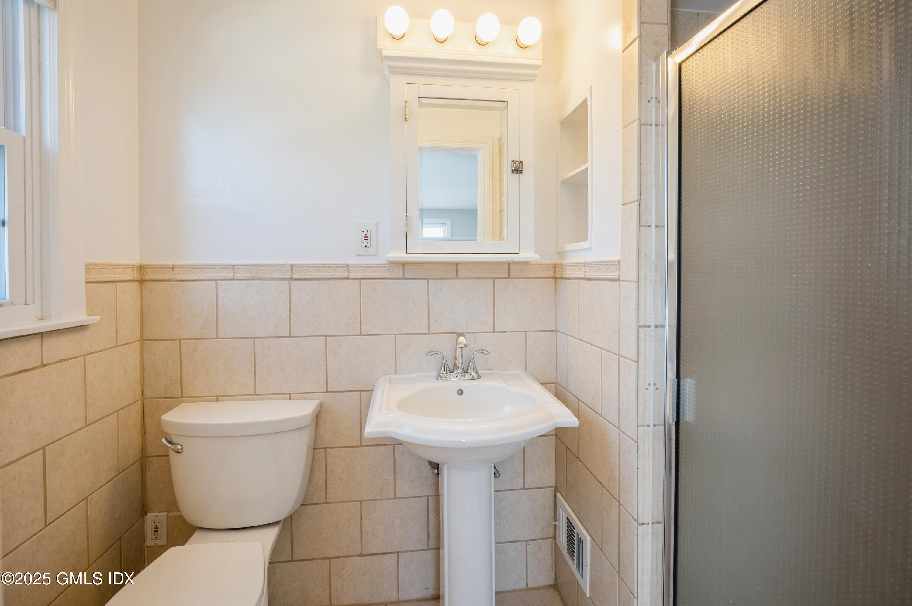 19 Bayside Terrace Riverside, CT 06878 - Photo 11 of 22 a bathroom with a sink toilet and a mirror