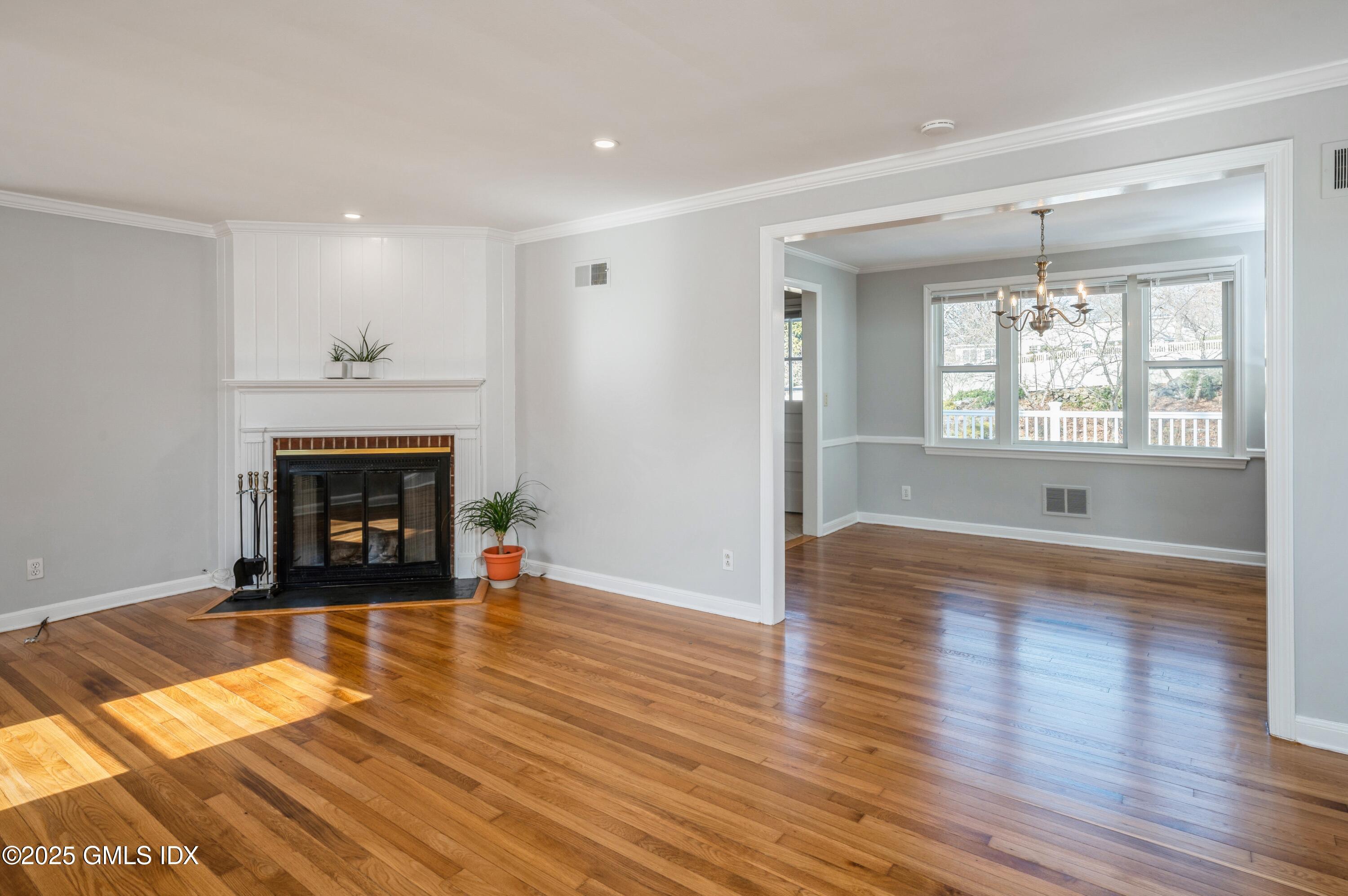 19 Bayside Terrace Riverside, CT 06878 - Photo 4 of 22 an empty room with wooden floor fireplace and windows