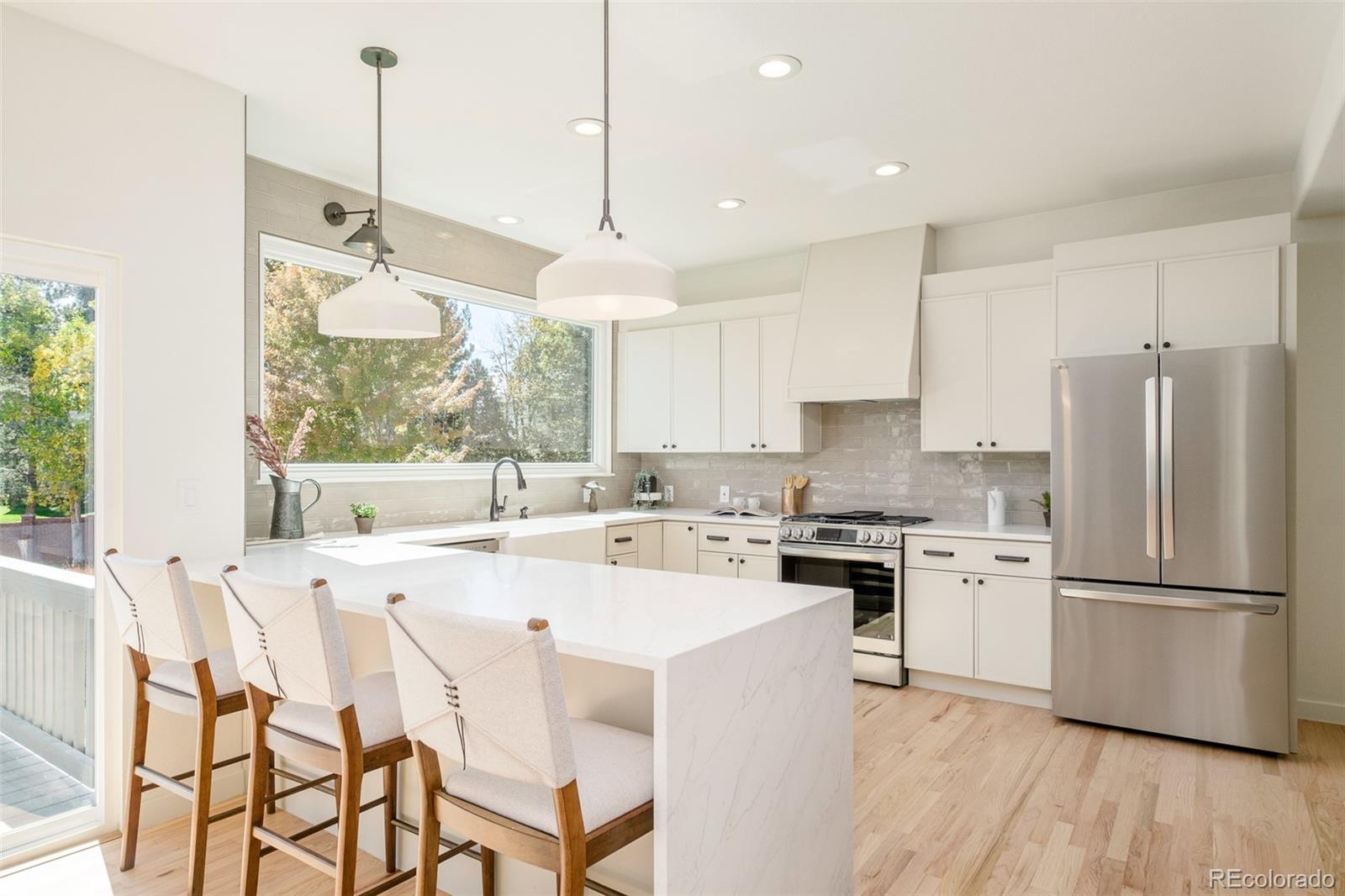 8176 Lone Oak Court Lone Tree, CO 80124 - Photo 9 of 50 a kitchen with stainless steel appliances granite countertop a stove a sink a refrigerator and white cabinets with wooden floor