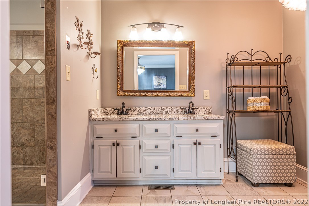 1075 Burning Tree Road Pinehurst, NC 28374 - Photo 13 of 25 a bathroom with a sink a mirror and a shower