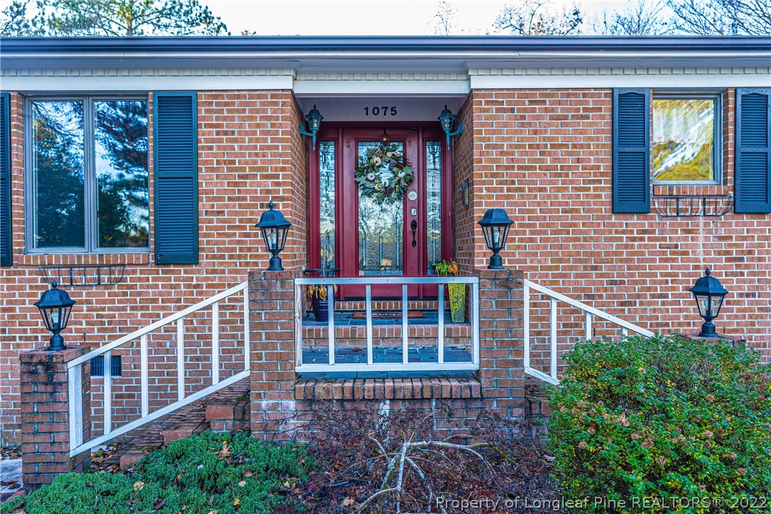 1075 Burning Tree Road Pinehurst, NC 28374 - Photo 2 of 25 a front view of a house with a large window and potted plants