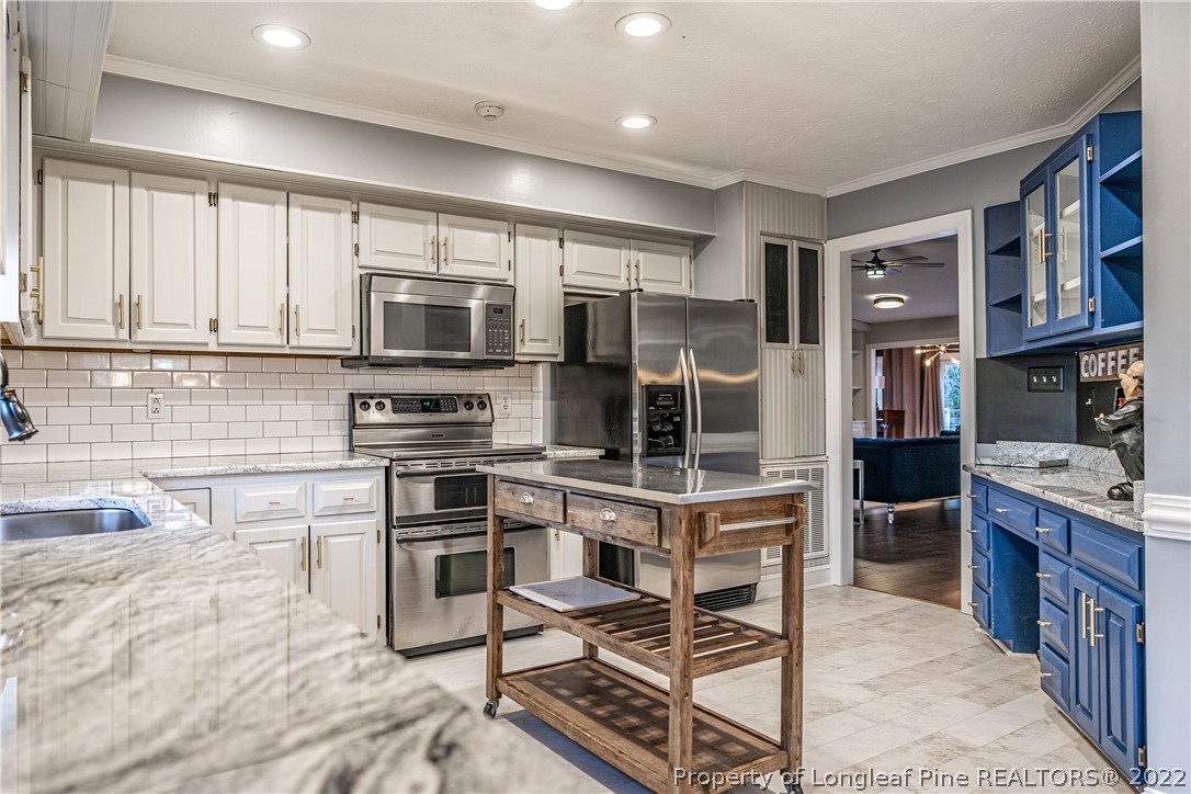 1075 Burning Tree Road Pinehurst, NC 28374 - Photo 7 of 25 a kitchen with stainless steel appliances a stove a sink and a refrigerator