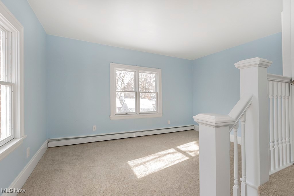 2596 Ashton Road Cleveland, OH 44118 - Photo 22 of 43 Empty room with plenty of natural light, light carpet, and a baseboard radiator