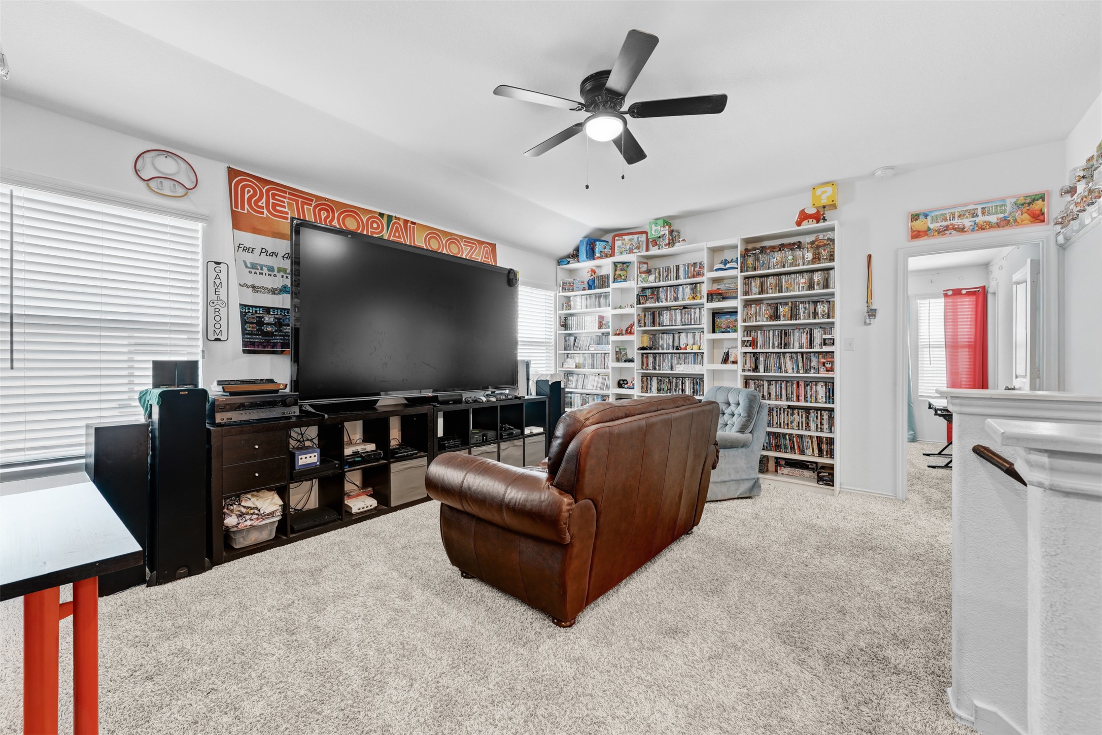 413 Perfect World Loop Jarrell, TX 76537 - Photo 24 of 39 A grand entertainment room boasts ample built-in shelving, providing extensive storage and display space.