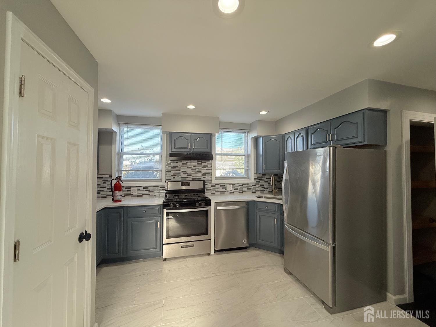 a kitchen with stainless steel appliances kitchen island granite countertop a refrigerator and a stove